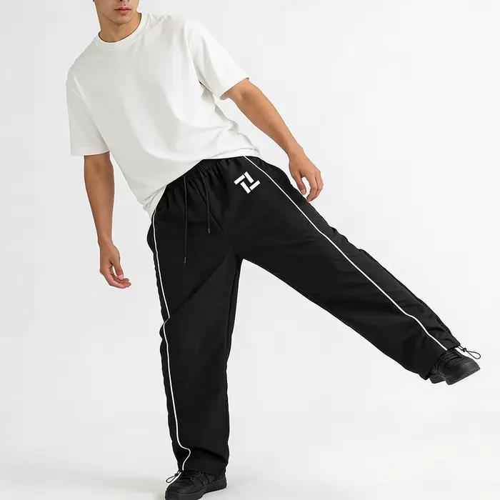 Pantalon de survêtement d'entraînement de fitness pour homme noir avec rayures latérales blanches imprimé géométrique pour sport et loisirs